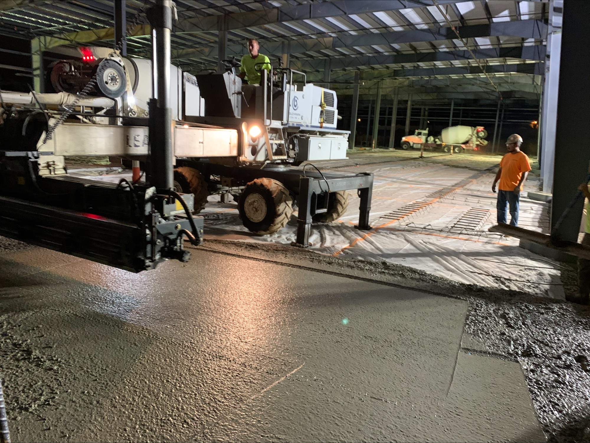 Laser screed machine placing a large commercial concrete slab at night