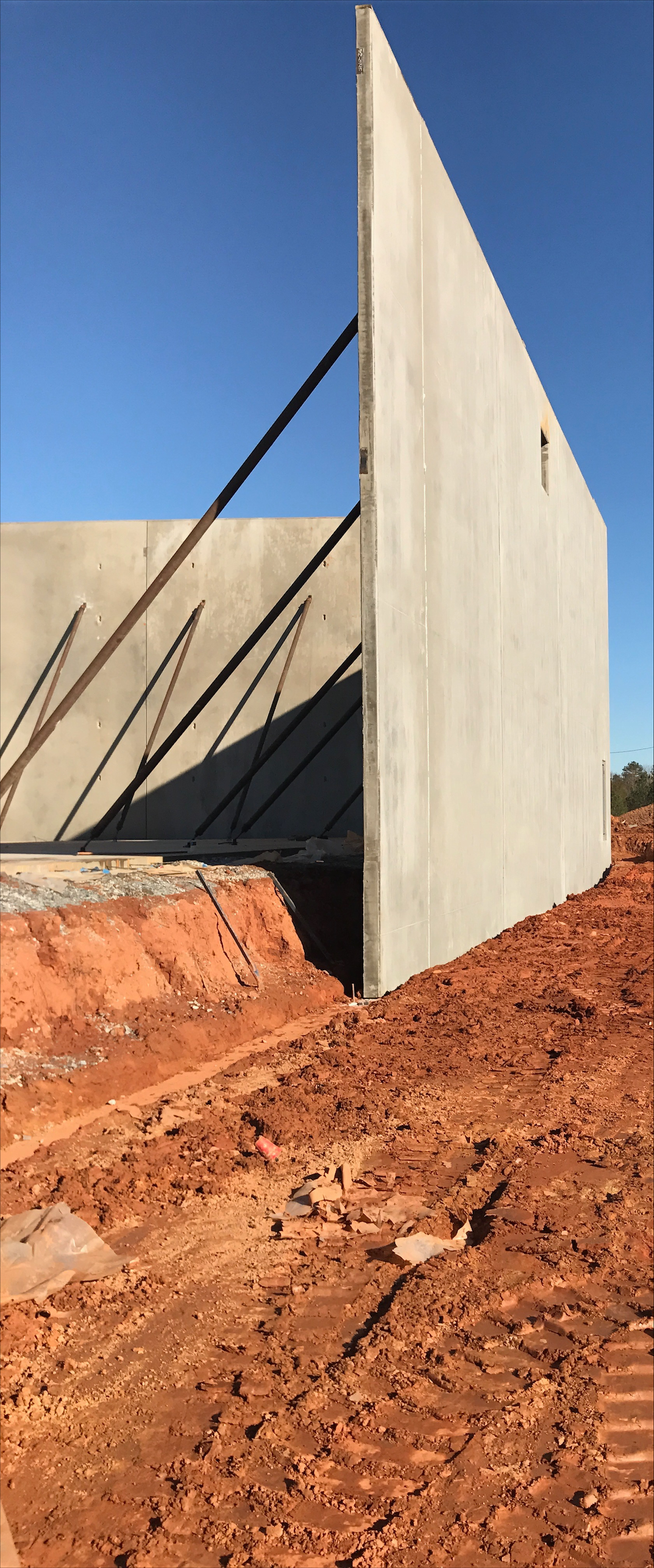 Single tilt-up concrete wall panel braced on red clay dirt